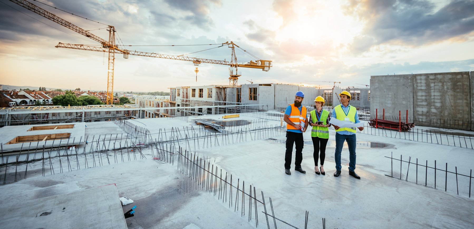 Arbeitnehmer im Baugewerbe stehen auf dem Dach eines im Bau befindlichen Gebäudes